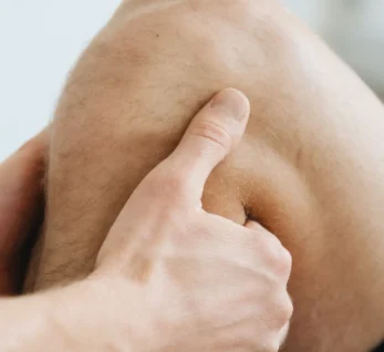 Hands holding a knee, illustrating knee joint pain treated with joint injections